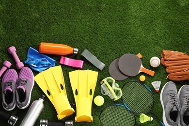 Photo of Different sport equipment on artificial grass, flat lay. Space for text