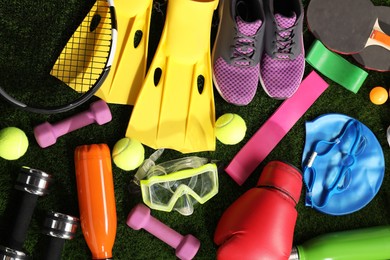 Photo of Different sport equipment on artificial grass, flat lay