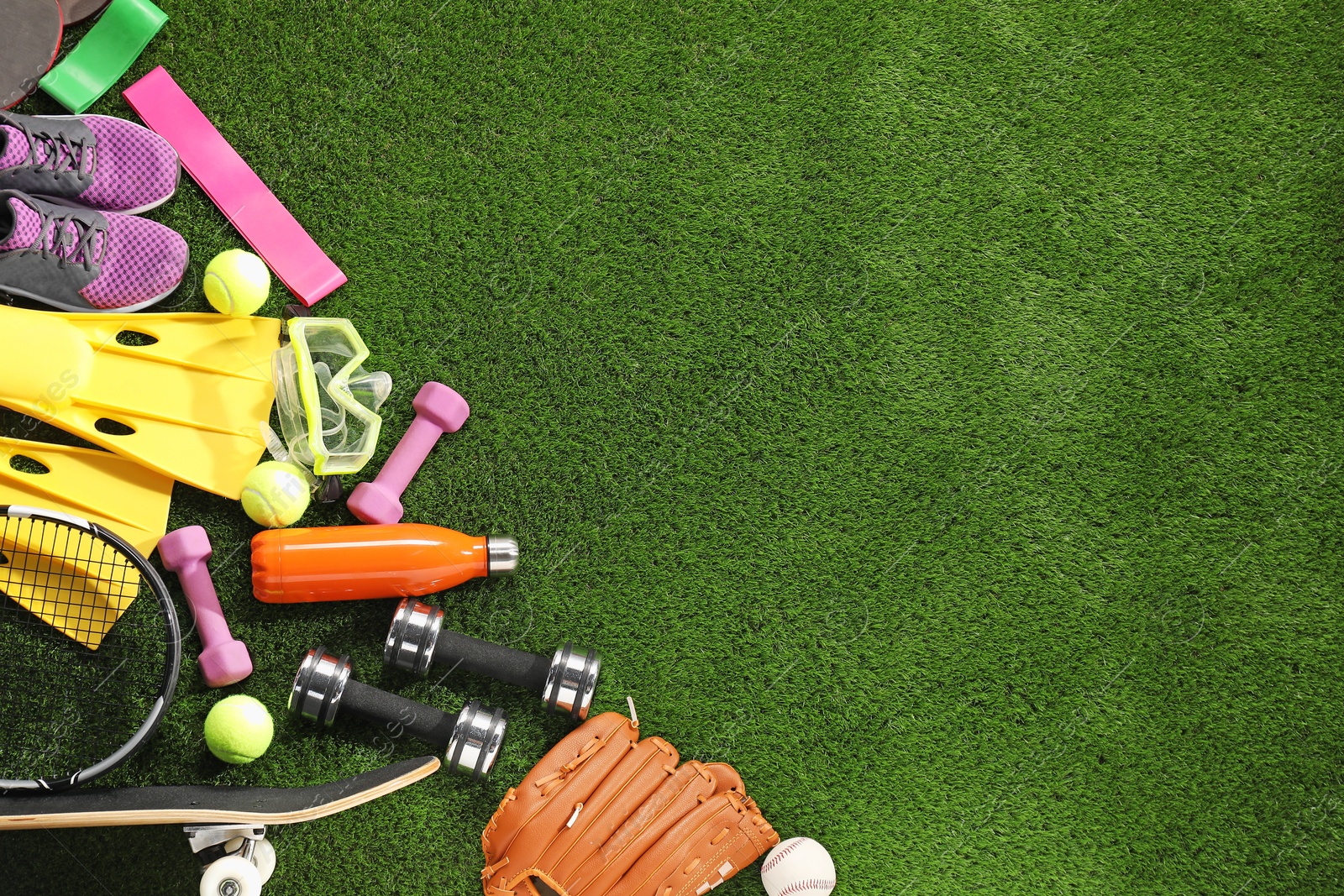 Photo of Different sport equipment on artificial grass, flat lay. Space for text