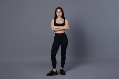 Photo of Portrait of woman in sportswear on grey background