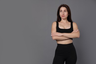 Photo of Portrait of woman in sportswear on grey background, space for text