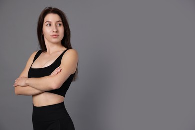 Photo of Portrait of woman in sportswear on grey background, space for text