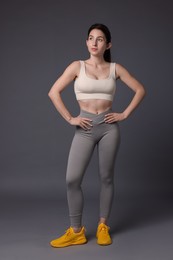 Photo of Portrait of woman in sportswear on grey background