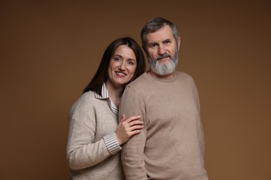 Photo of Family portrait of happy daughter and her father on brown background