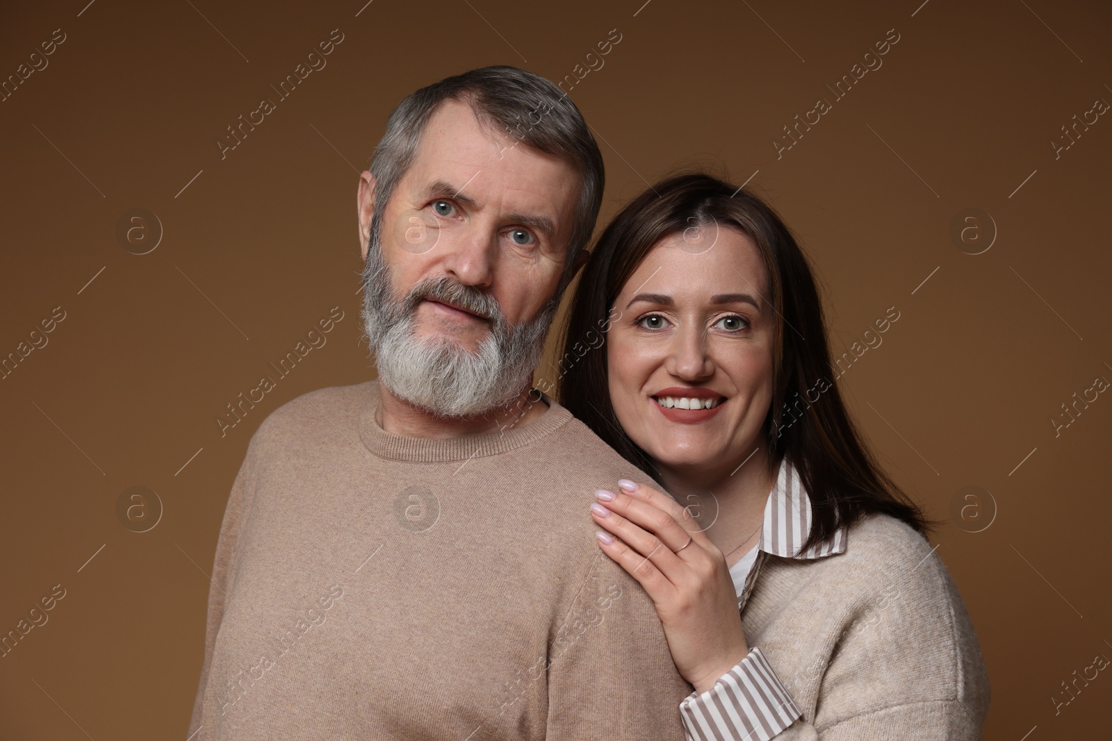 Photo of Family portrait of happy daughter and her father on brown background