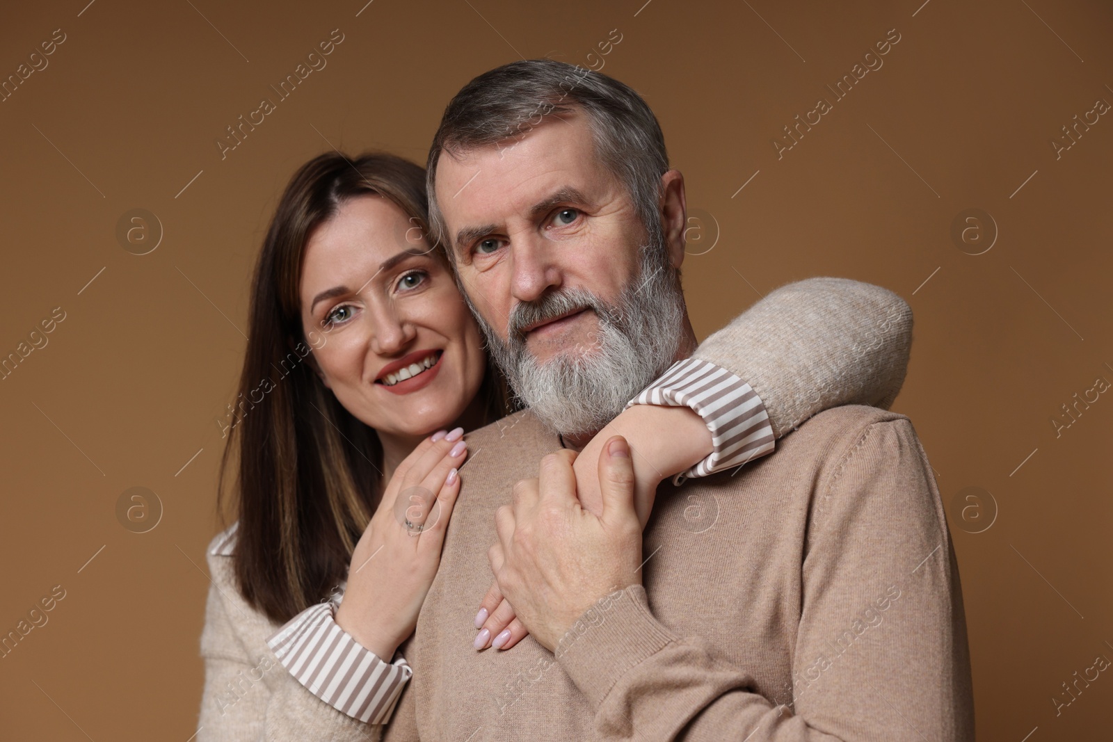 Photo of Family portrait of happy daughter and her father on brown background