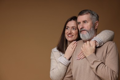 Photo of Happy daughter and her father on brown background, space for text