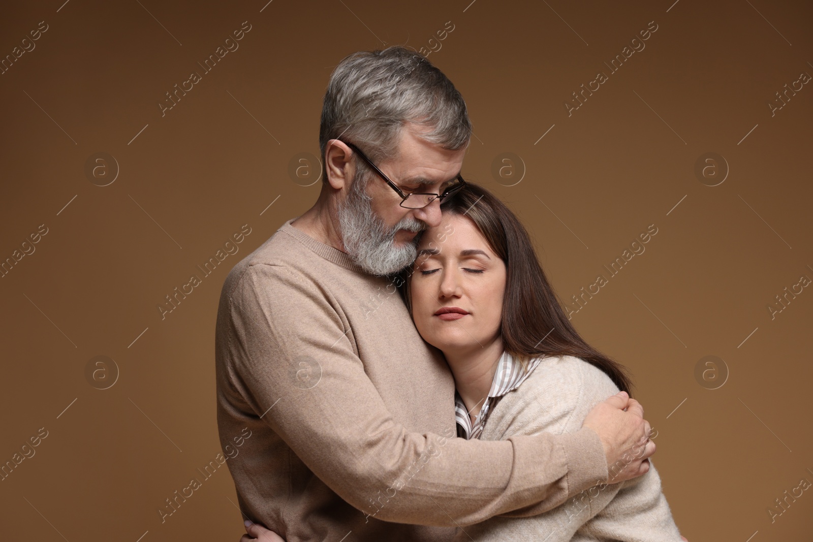 Photo of Father hugging his daughter on brown background