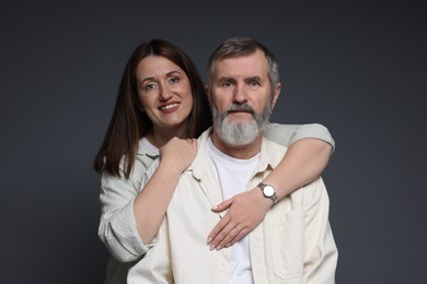 Photo of Happy daughter hugging her father on dark background