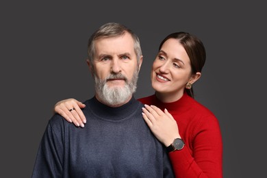 Photo of Family portrait of happy daughter and her father on dark background