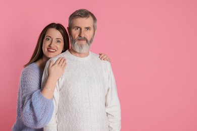 Photo of Family portrait of happy daughter and her father on pink background, space for text