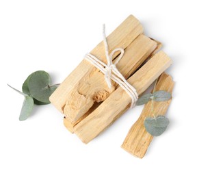 Photo of Palo santo sticks and eucalyptus branches isolated on white, top view