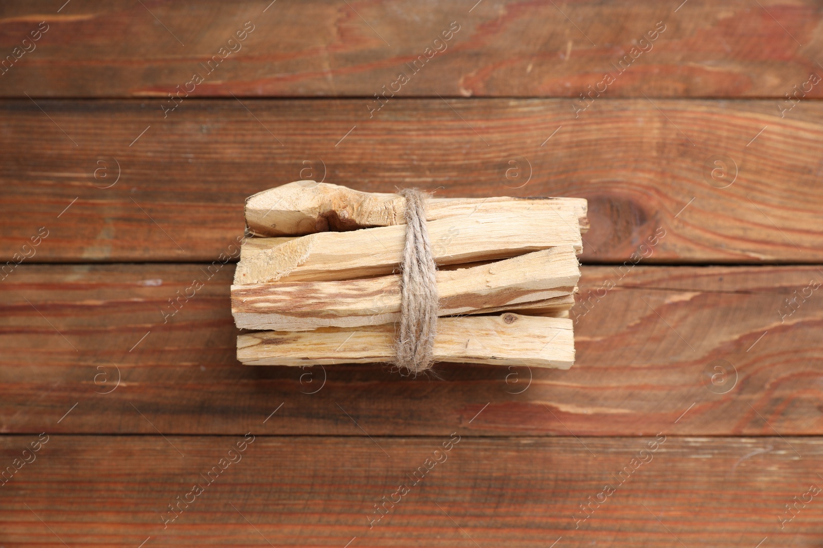 Photo of Bunch of palo santo sticks on wooden table, above view