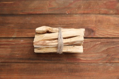 Photo of Bunch of palo santo sticks on wooden table, above view