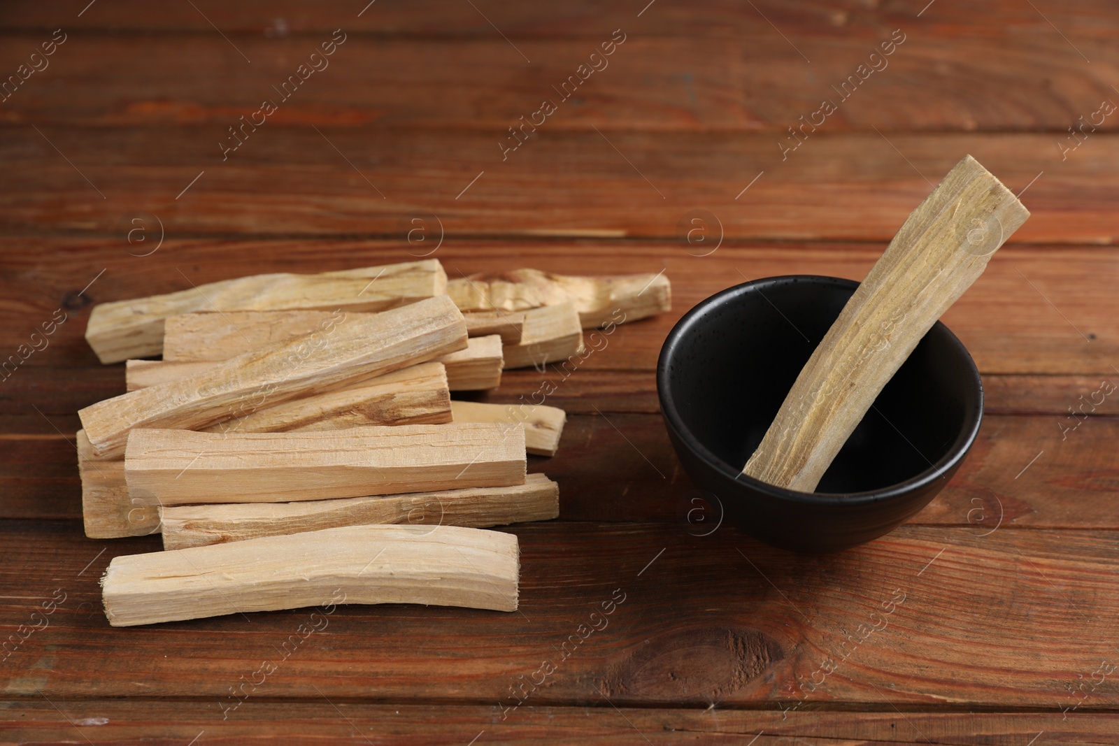 Photo of Palo santo sticks on wooden table, closeup