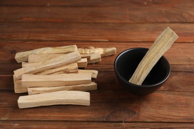 Photo of Palo santo sticks on wooden table, closeup