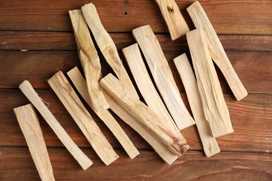 Photo of Palo santo sticks on wooden table, flat lay