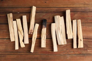 Photo of Palo santo sticks on wooden table, flat lay