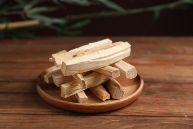 Photo of Palo santo sticks on wooden table, closeup