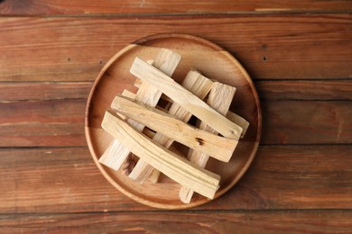 Photo of Palo santo sticks on wooden table, top view