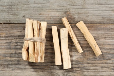 Photo of Palo santo sticks on wooden table, flat lay