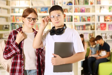 Photo of Teenage friends with laptop in public library