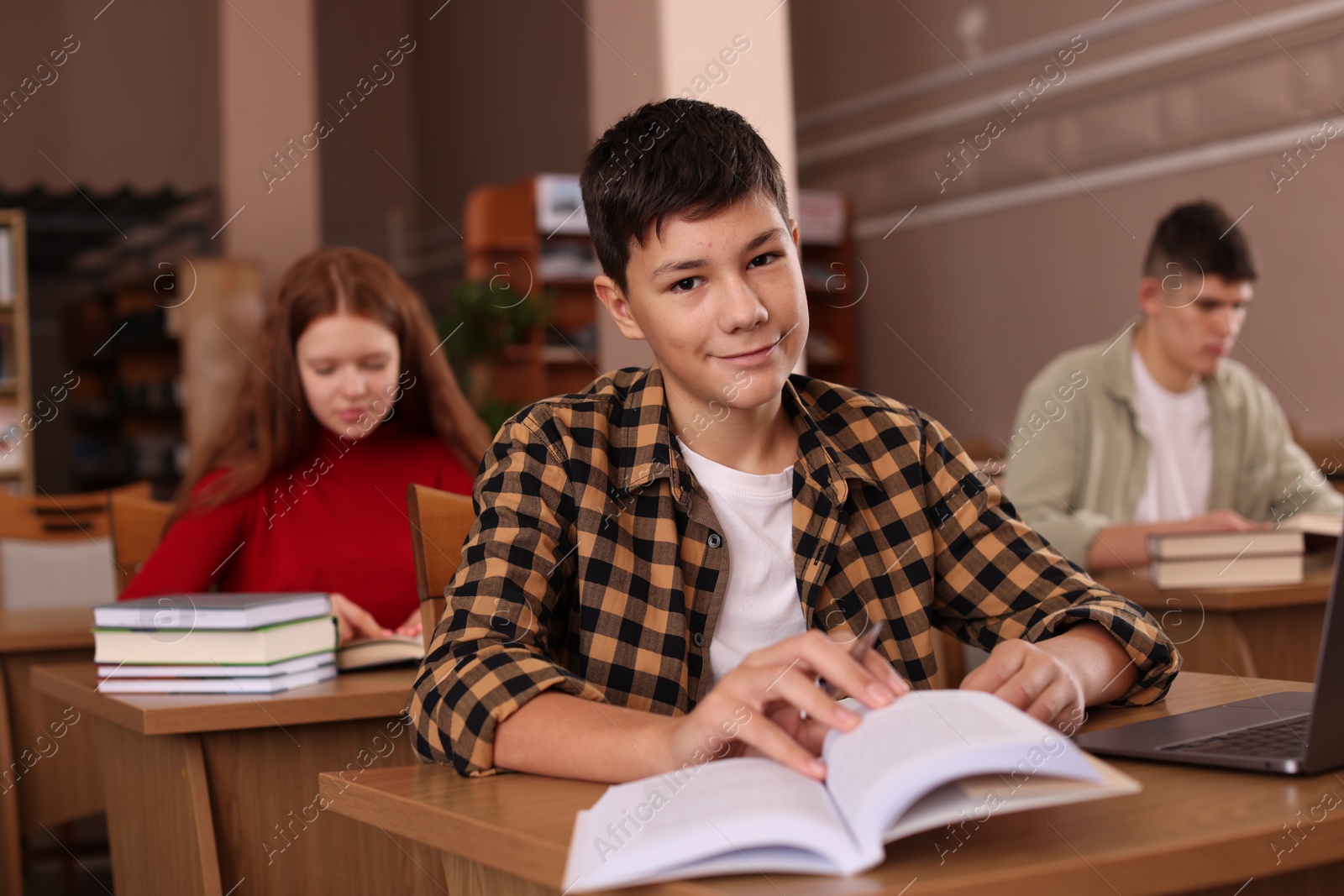 Photo of Boy studying at desk in public library