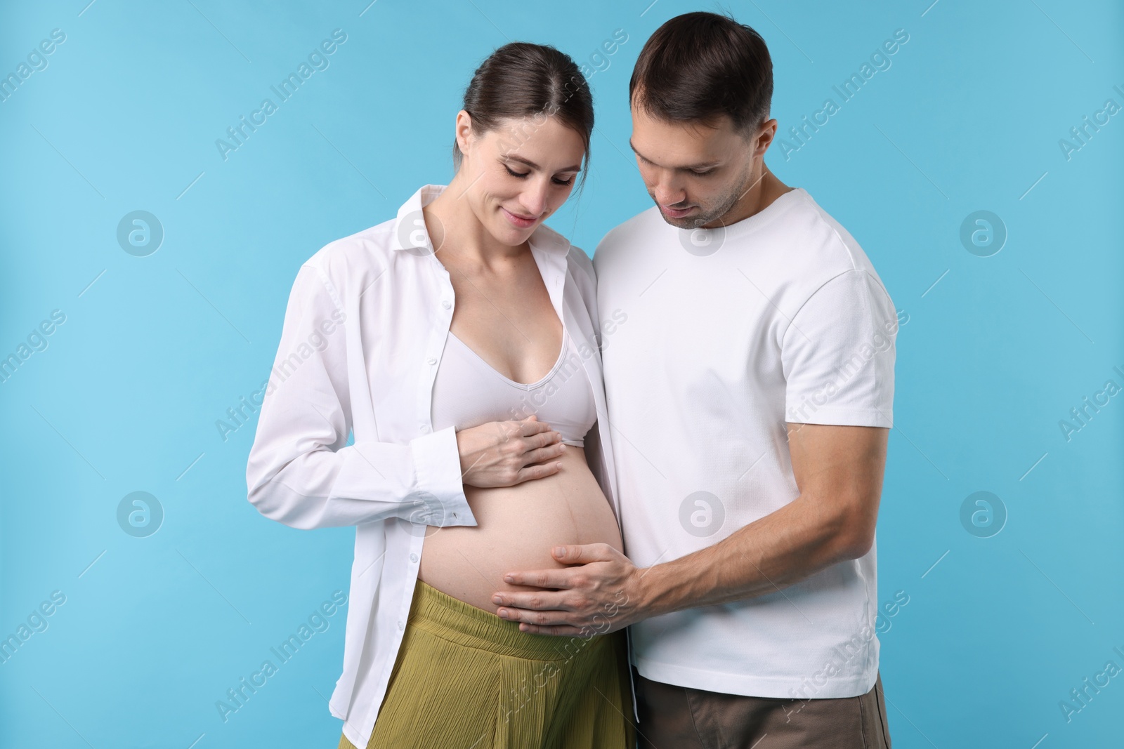 Photo of Pregnant woman and her husband on blue background