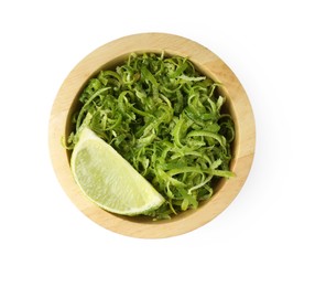 Photo of Lime zest and slice of fruit in bowl isolated on white, top view