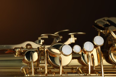 Photo of Jazz. One beautiful saxophone on brown background, closeup