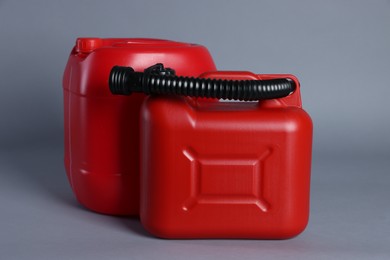 Photo of Two red plastic canisters on light grey background