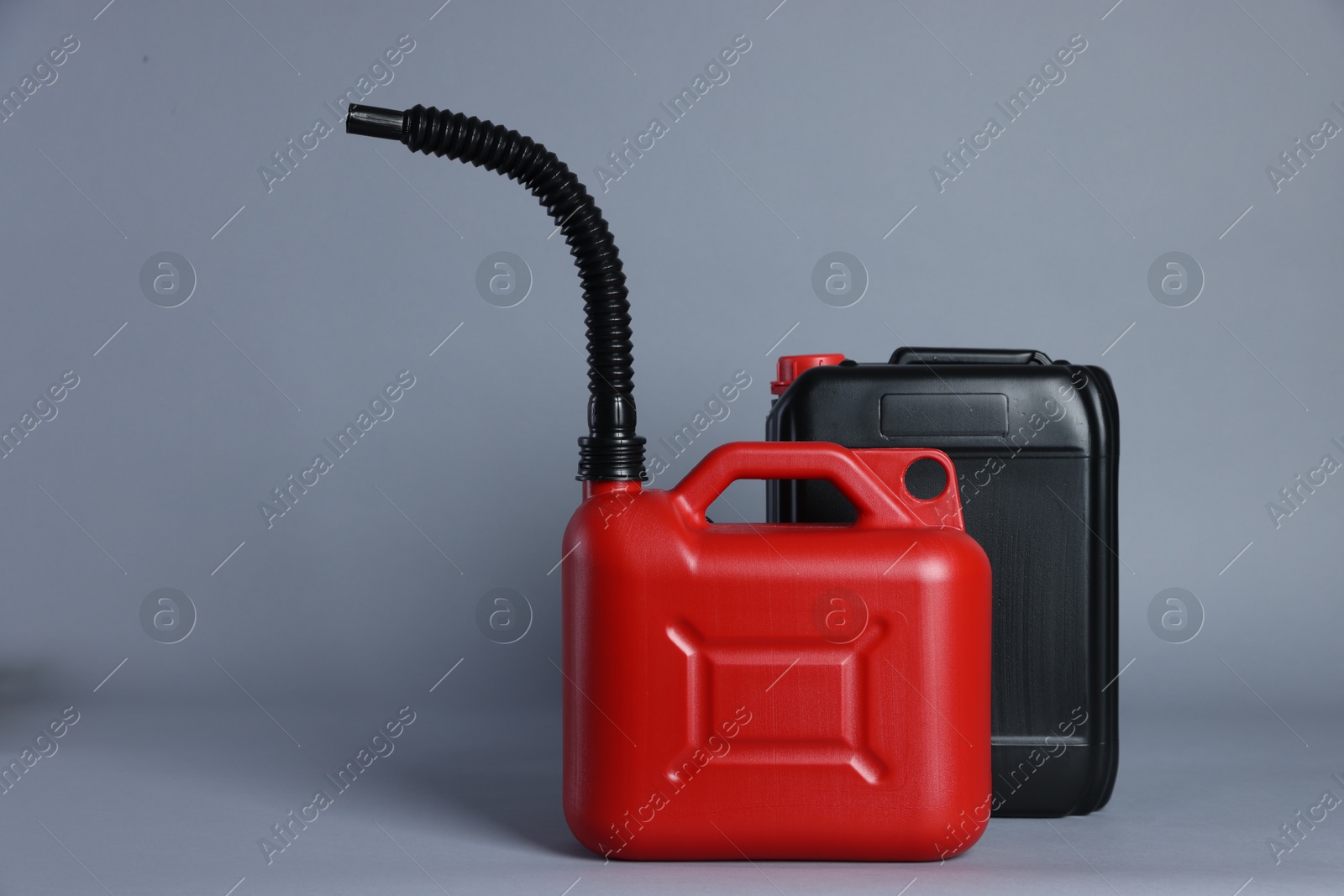 Photo of Two plastic canisters on light grey background, space for text