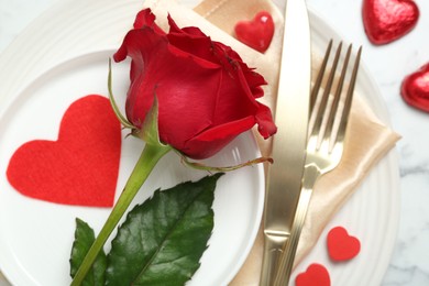 Photo of Romantic place setting for Valentine's day. Rose, tableware, cutlery and decorative hearts on white table, flat lay