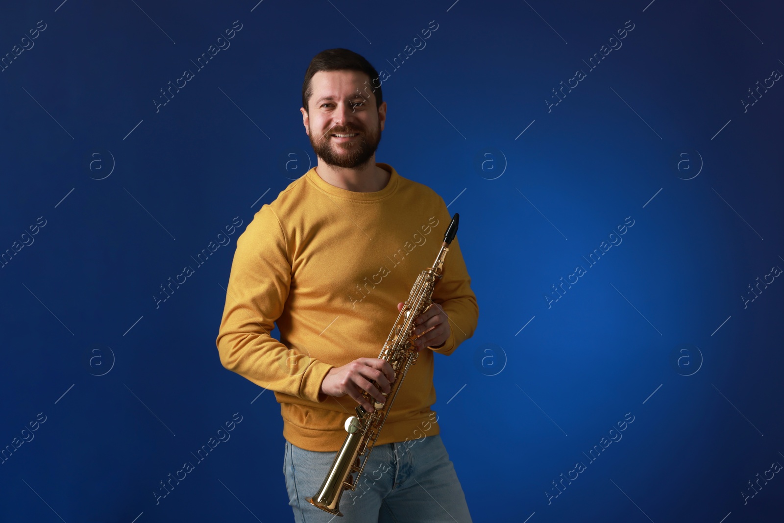 Photo of Professional musician with soprano saxophone on blue background