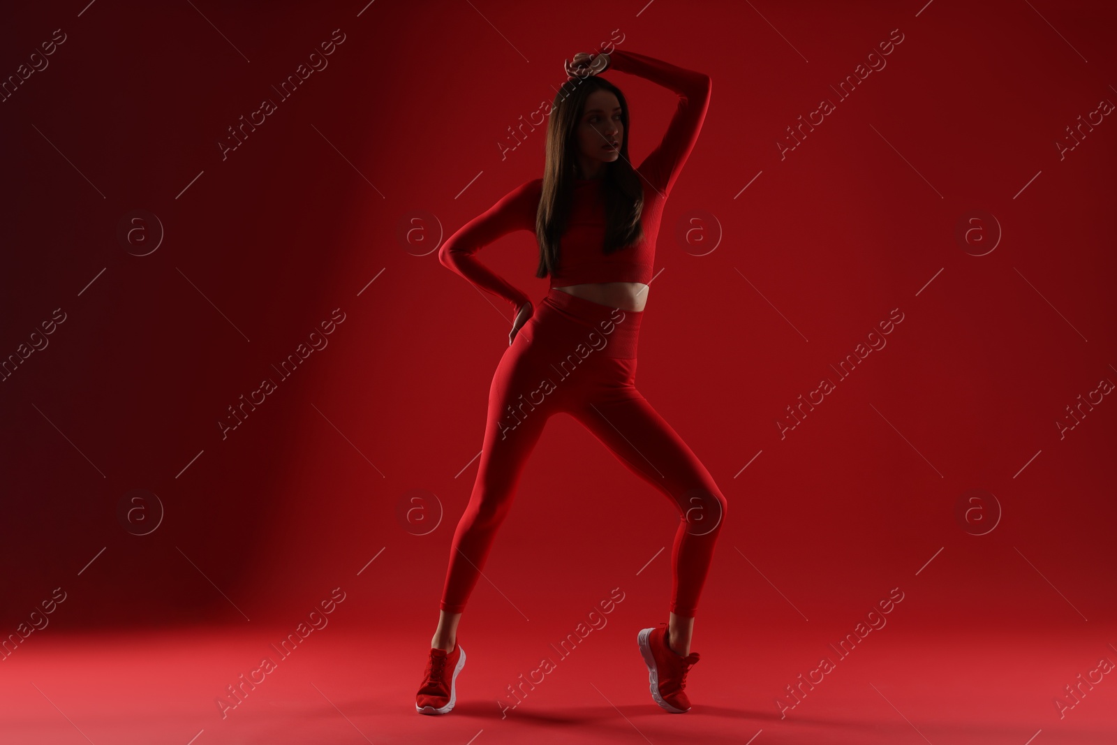 Photo of Silhouette of woman in sportswear on red background