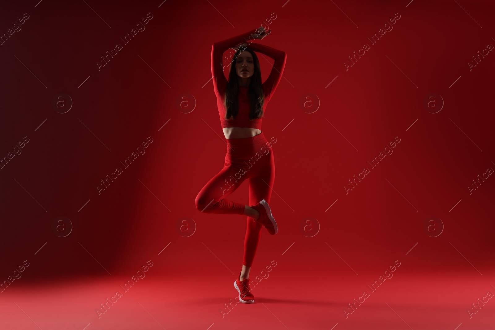 Photo of Silhouette of woman in sportswear on red background