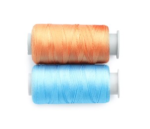 Photo of Spools of bright sewing threads isolated on white, top view