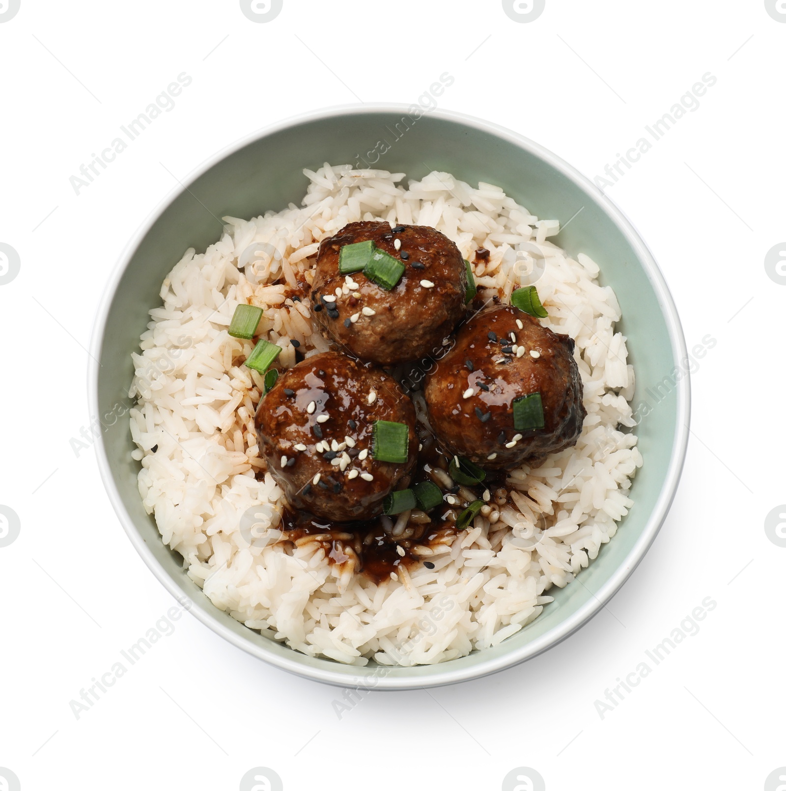 Photo of Delicious rice with meatballs, sauce and green onions in bowl isolated on white, top view