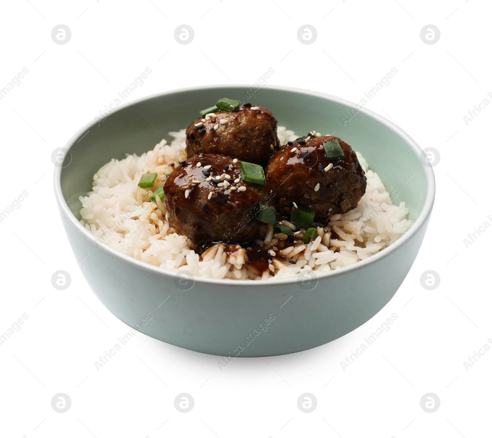 Photo of Delicious rice with meatballs, sauce and green onions in bowl isolated on white