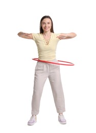 Smiling woman training with hula hoop on white background