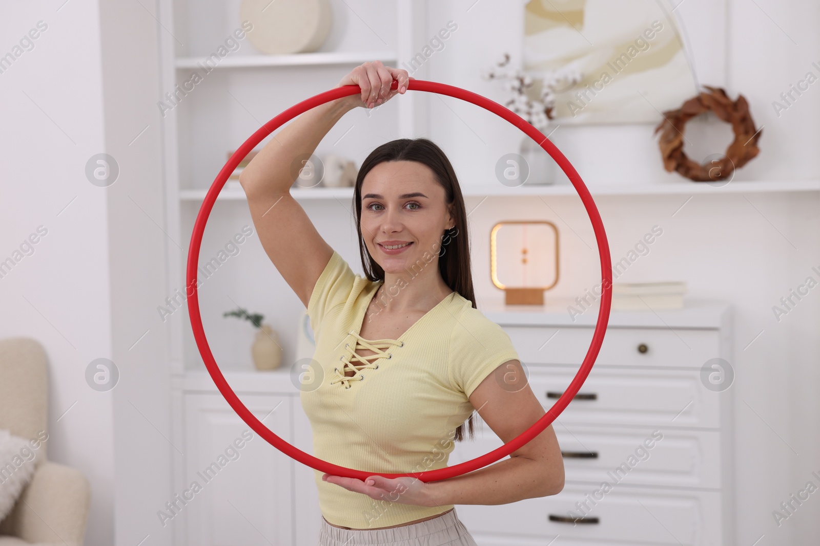 Photo of Smiling woman with hula hoop at home