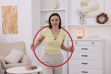 Photo of Smiling woman with hula hoop at home