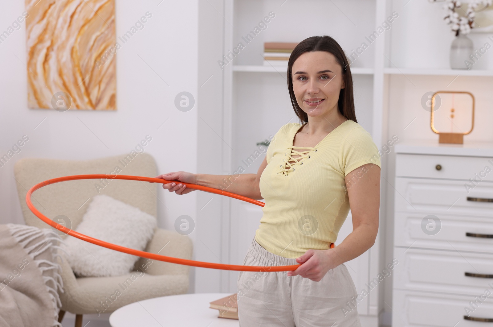 Photo of Smiling woman with hula hoop at home