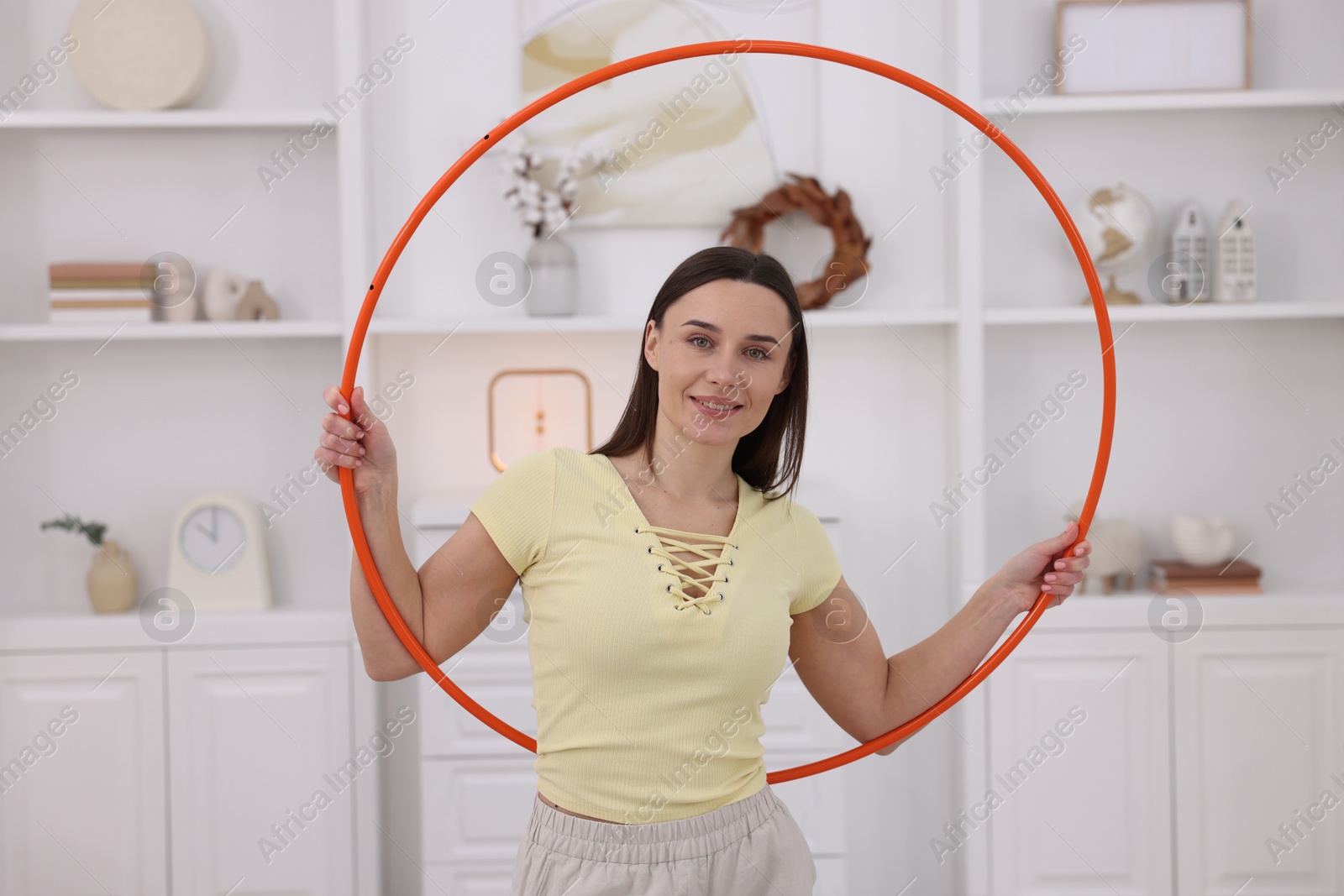 Photo of Smiling woman with hula hoop at home