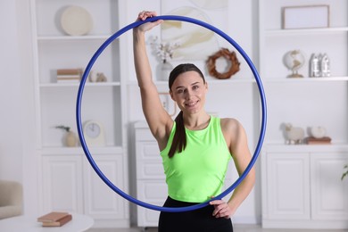 Photo of Smiling woman with hula hoop at home