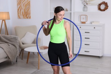 Photo of Smiling woman with hula hoop at home