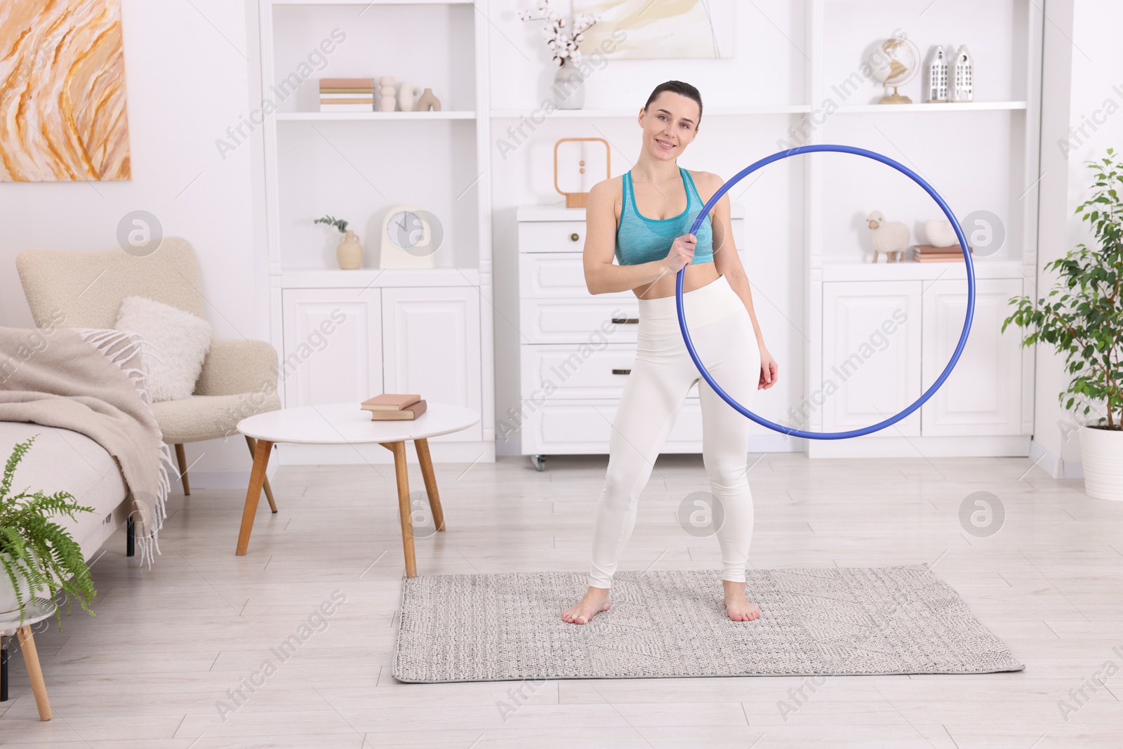 Photo of Smiling woman with hula hoop at home