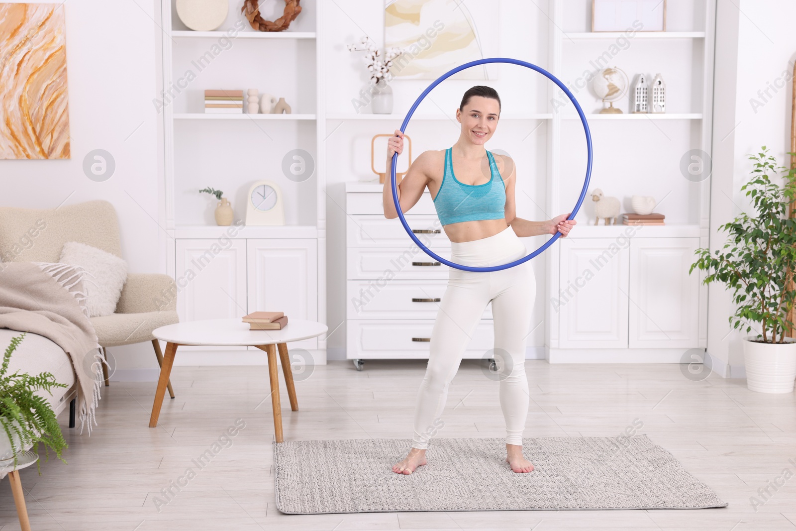 Photo of Smiling woman with hula hoop at home