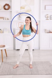 Photo of Smiling woman with hula hoop at home