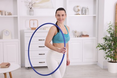 Photo of Smiling woman with hula hoop at home